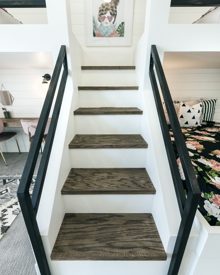 Custom bunk bed staircase with warm wood treads and black metal railings in girls' bedroom, Reveal Interior Design Las Vegas