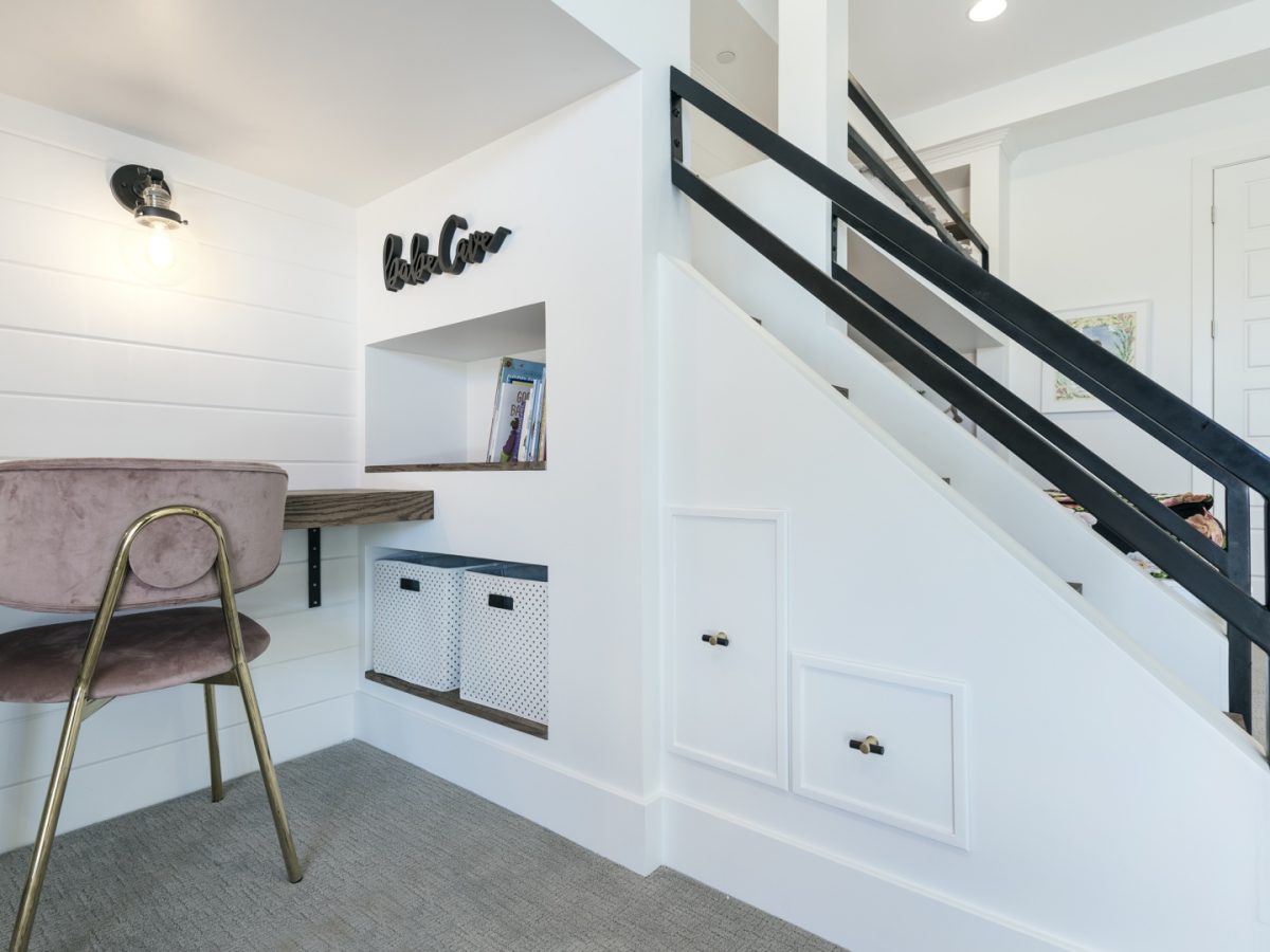 Girls' bedroom study nook with built-in shelving, floating desk, and stair storage, Reveal Interior Design Las Vegas