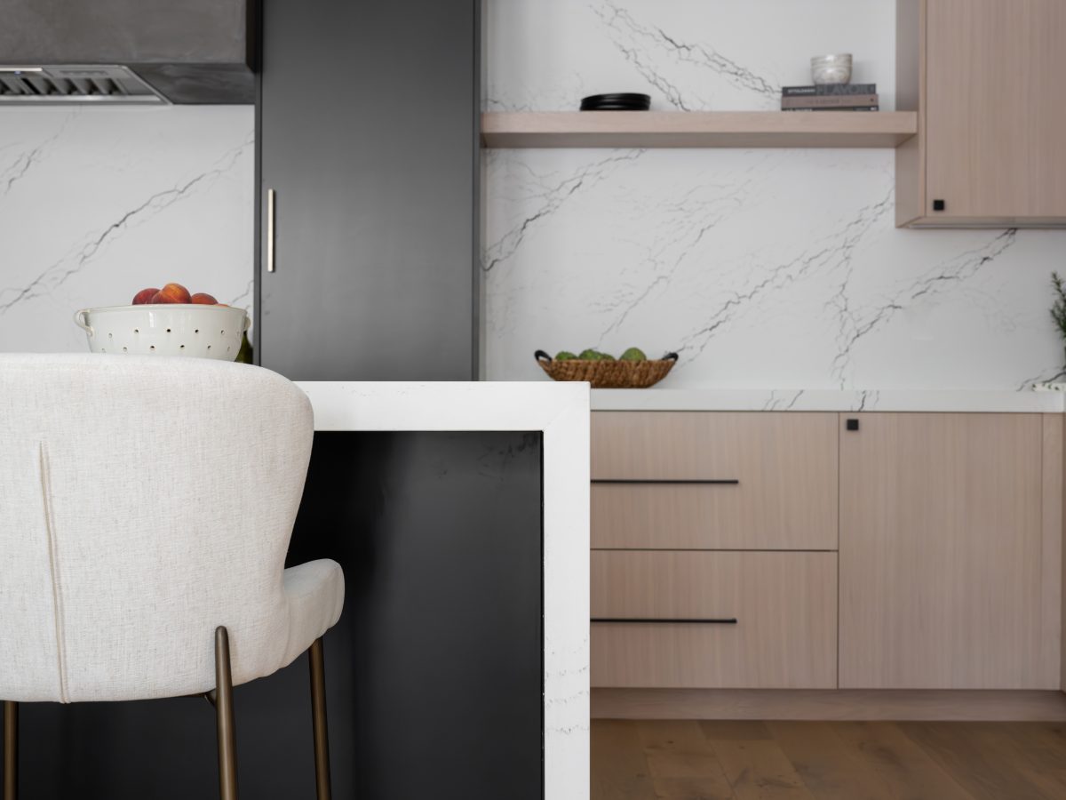 Modern kitchen with white-washed oak cabinetry, black quartz backsplash, and amber pendant lighting, Reveal Interior Design Las Vegas