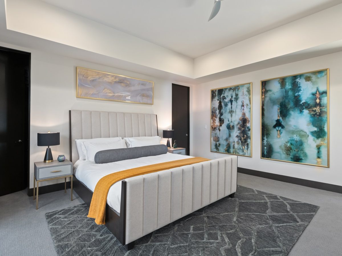 Casita king bedroom suite with channeled tufted bed, walnut accents, and oversized abstract artwork, Reveal Interior Design Las Vegas