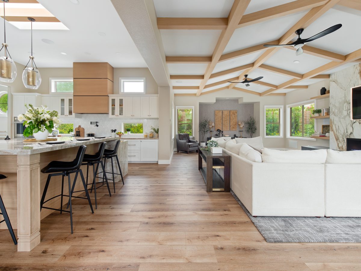 Open-concept living room with bookmatched porcelain fireplace surround and oak beam ceiling, Reveal Interior Design Las Vegas
