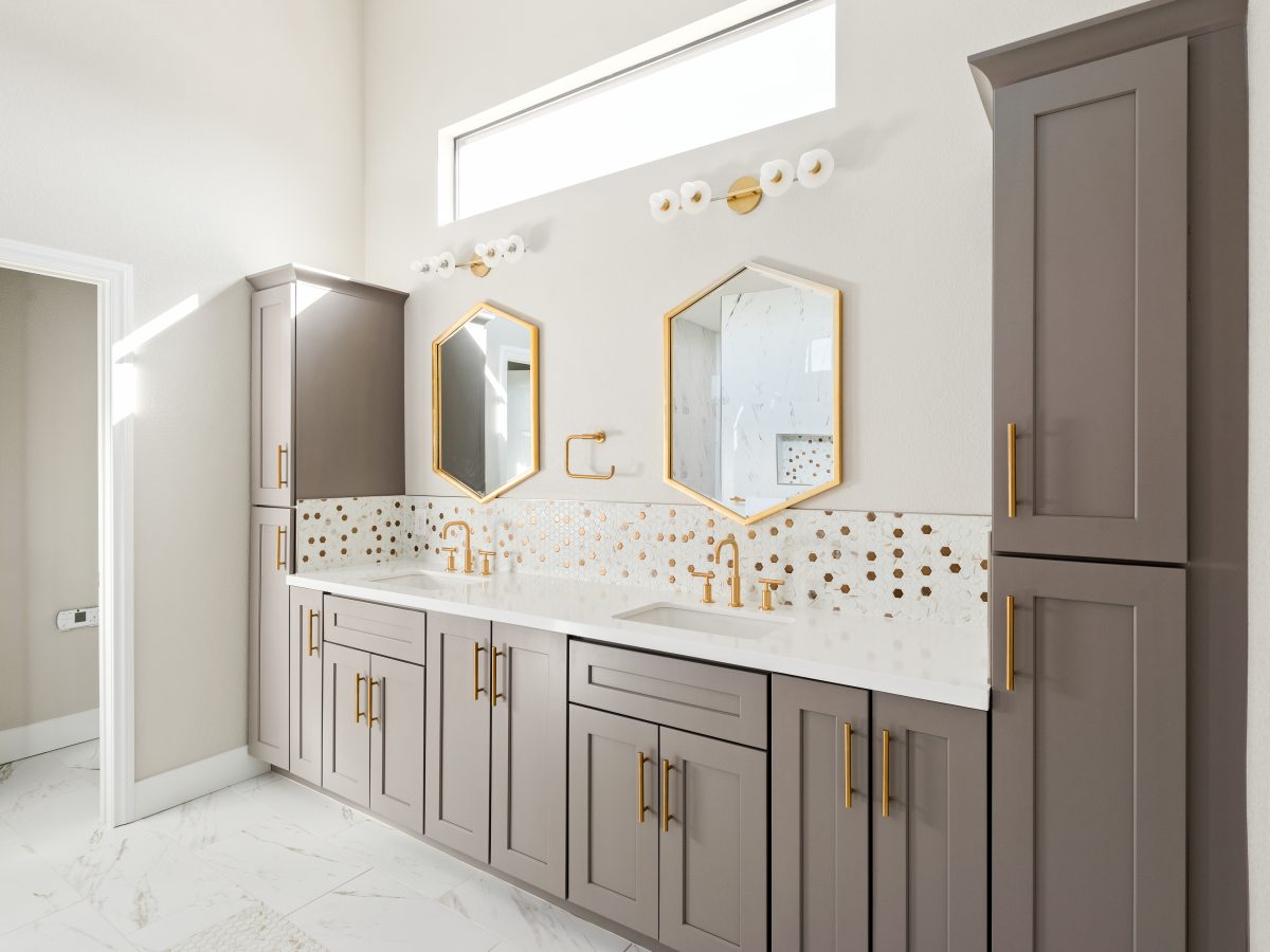 Primary bathroom with taupe shaker cabinetry, gold mosaic tile backsplash, and geometric mirrors, Reveal Interior Design Las Vegas