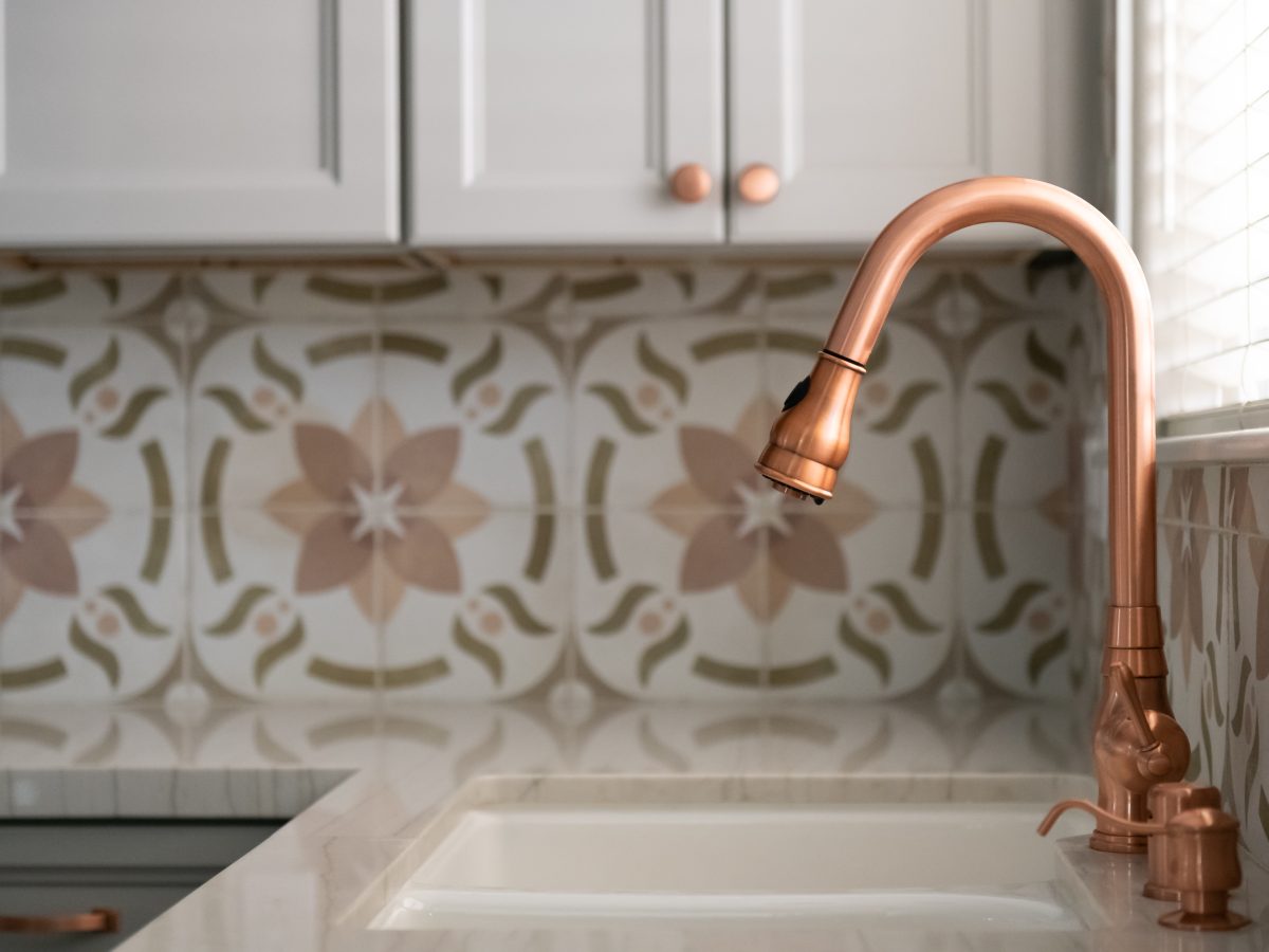 Kitchen sink detail with copper gooseneck faucet and encaustic ceramic tile backsplash, Reveal Interior Design Las Vegas