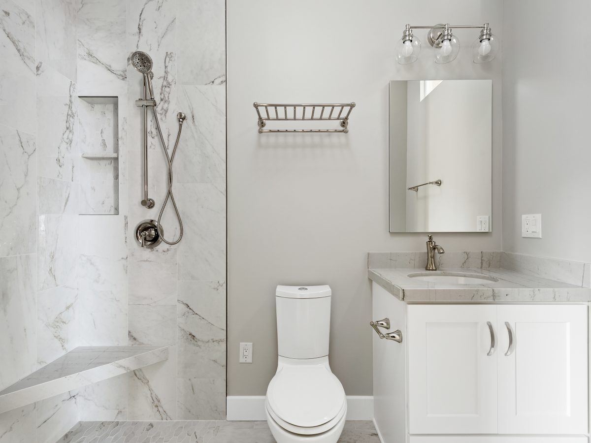 Transitional guest bathroom with marble-look porcelain tile and Taj Mahal quartzite vanity, Reveal Interior Design Las Vegas