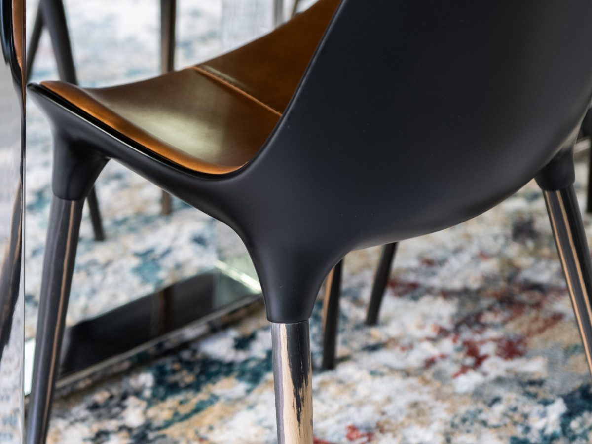 Dining room with custom live-edge wood table, two-tone leather seating, and colorful area rug, Reveal Interior Design Las Vegas