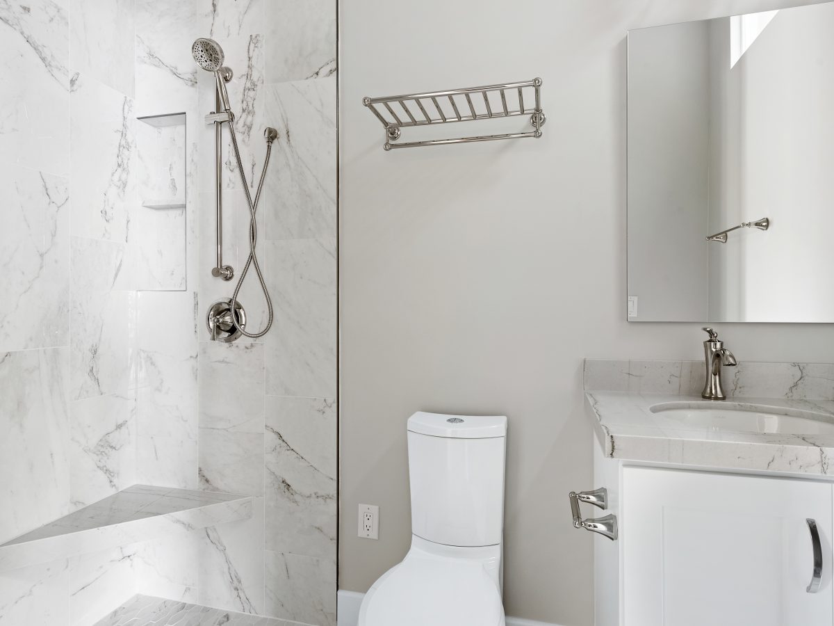 Transitional guest bathroom with marble-look porcelain tile shower and Taj Mahal quartzite vanity, Reveal Interior Design Las Vegas