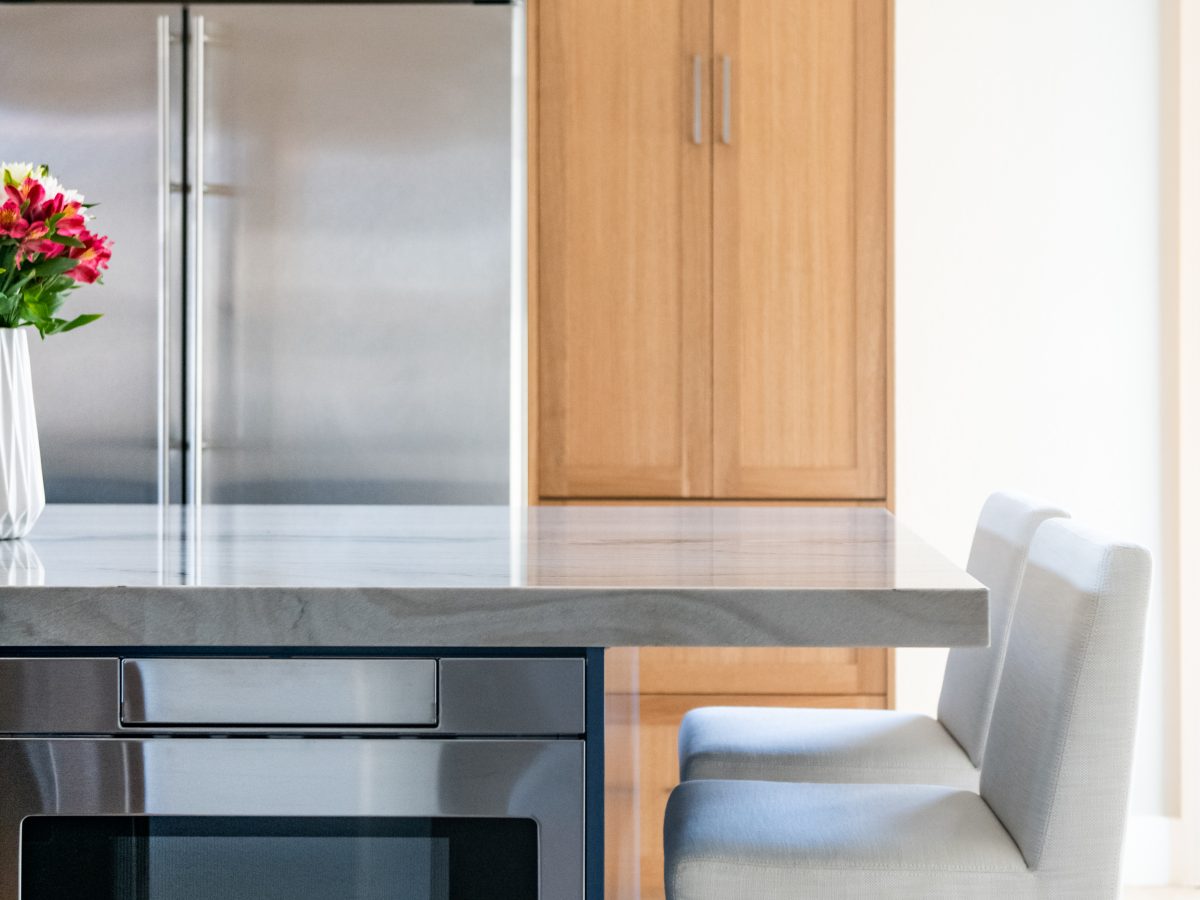 Kitchen with blue island, warm oak cabinetry, and quartzite countertops, Reveal Interior Design Las Vegas
