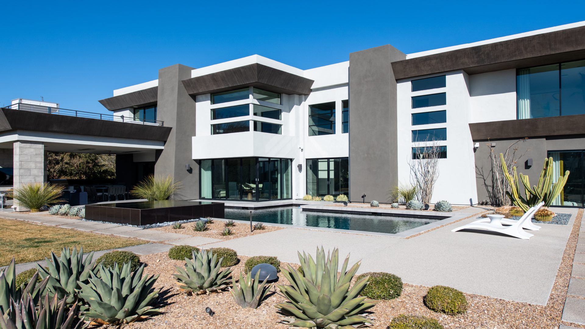 Desert Modern luxury estate exterior with geometric pool and xeriscape landscaping, Reveal Interior Design Las Vegas