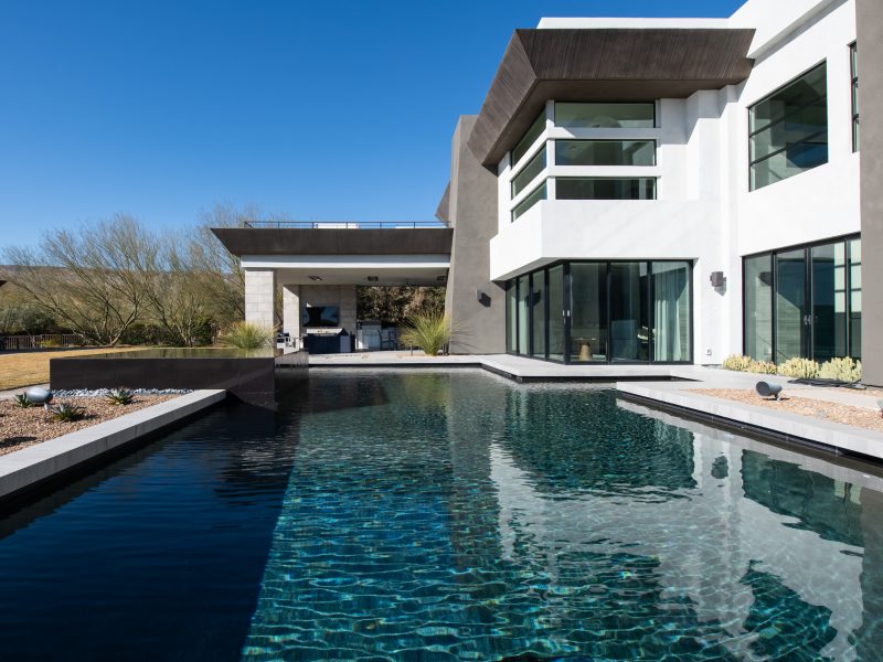 Desert Modern backyard with lap pool, casita bar seating, and Las Vegas Strip views, Reveal Interior Design Las Vegas