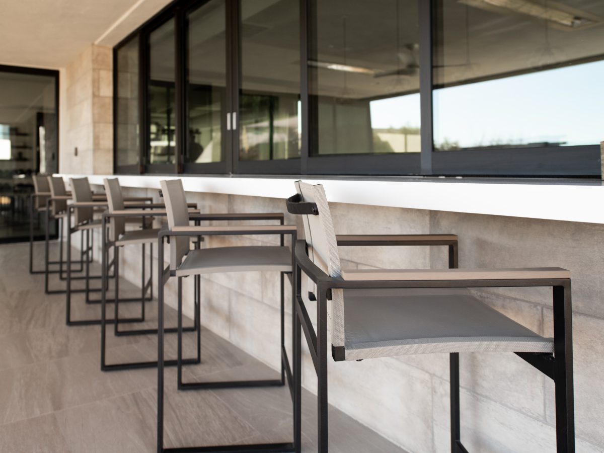 Outdoor bar seating with modern metal stools at covered casita counter, Reveal Interior Design Las Vegas