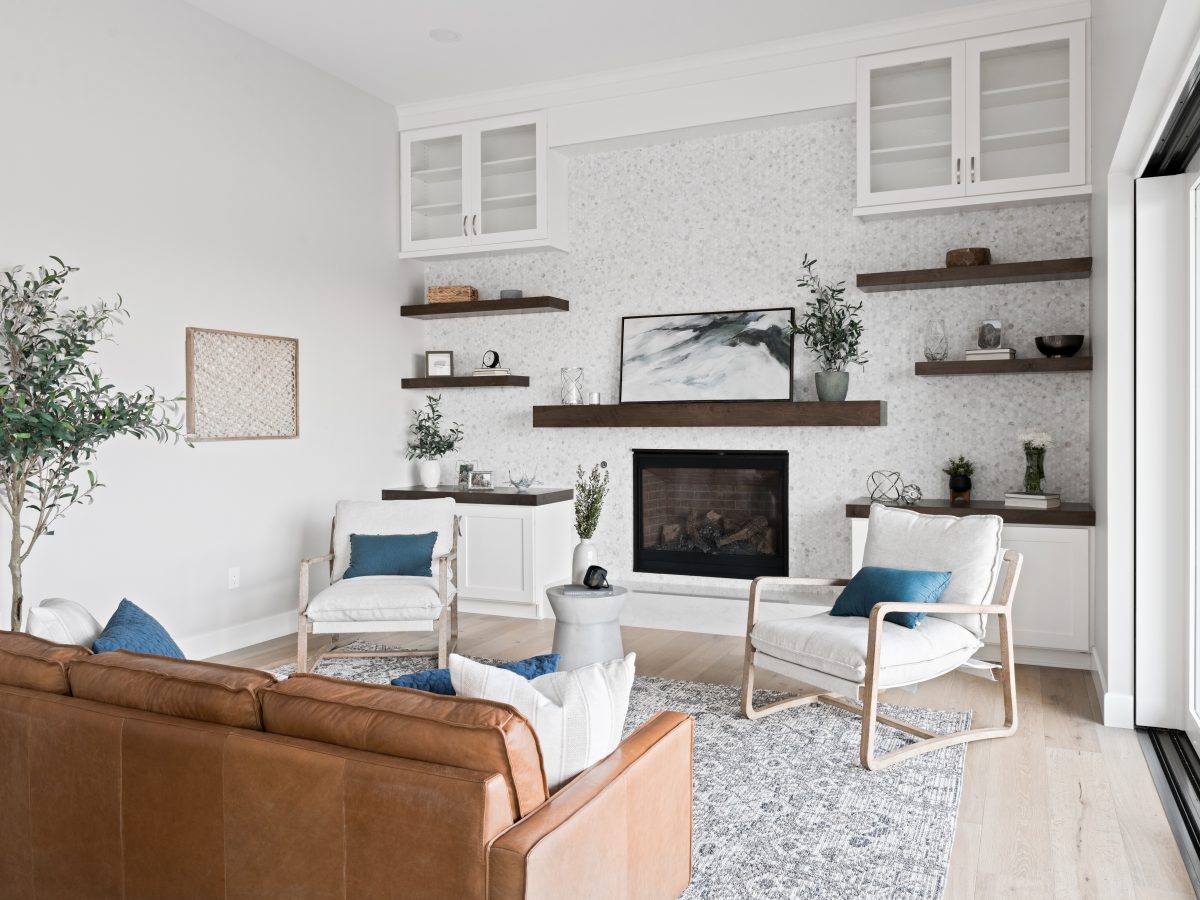 Family room with geometric marble tile fireplace wall, dark stained floating shelves and mantel, Reveal Interior Design Las Vegas
