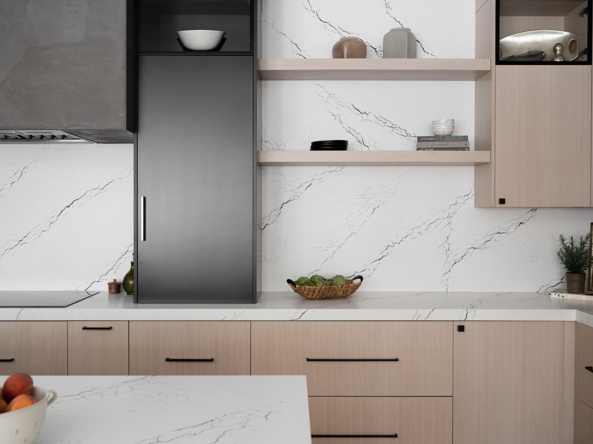 Modern kitchen with white quartz countertops and backsplash, whitewashed oak cabinetry, matte black accents, Reveal Interior Design Las Vegas