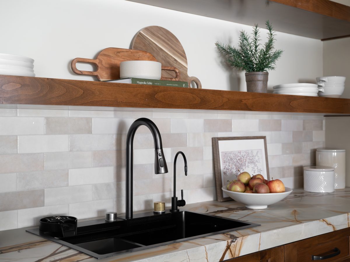 Kitchen prep sink area with black pull-down faucet, floating maple shelves, and marbled-look quartz countertops, Reveal Interior Design Las Vegas