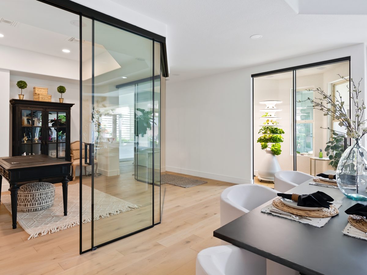 Glass-walled home office with black metal framing and oak engineered flooring, Reveal Interior Design Las Vegas