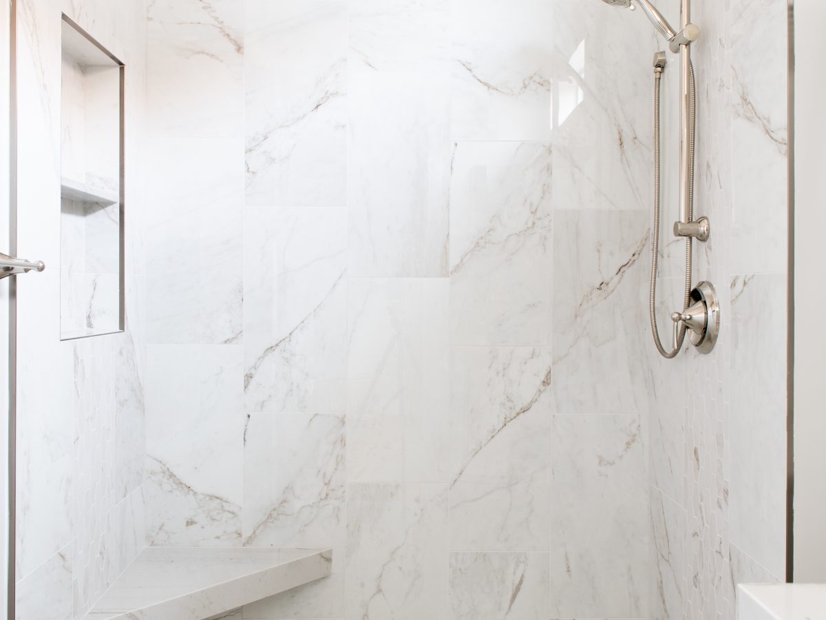 Walk-in shower with marble-look porcelain tile and polished nickel fixtures, Reveal Interior Design Las Vegas