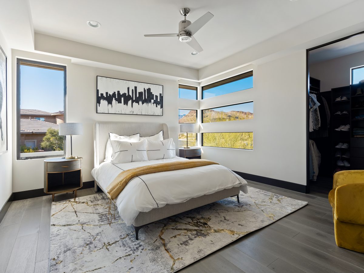 Desert Modern secondary bedroom with gold accents, corner windows, and walk-in closet, Reveal Interior Design Las Vegas