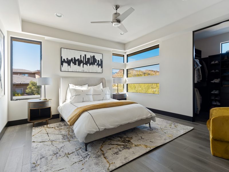 Desert Modern secondary bedroom with gold accents, corner windows, and walk-in closet, Reveal Interior Design Las Vegas