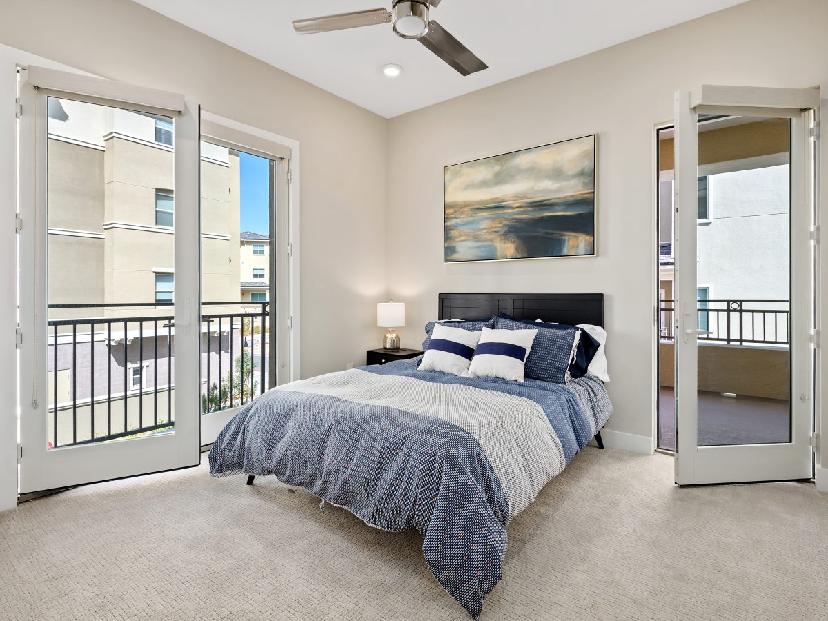 Contemporary guest bedroom with taupe carpet, warm brown headboard, and large abstract art, Reveal Interior Design Las Vegas