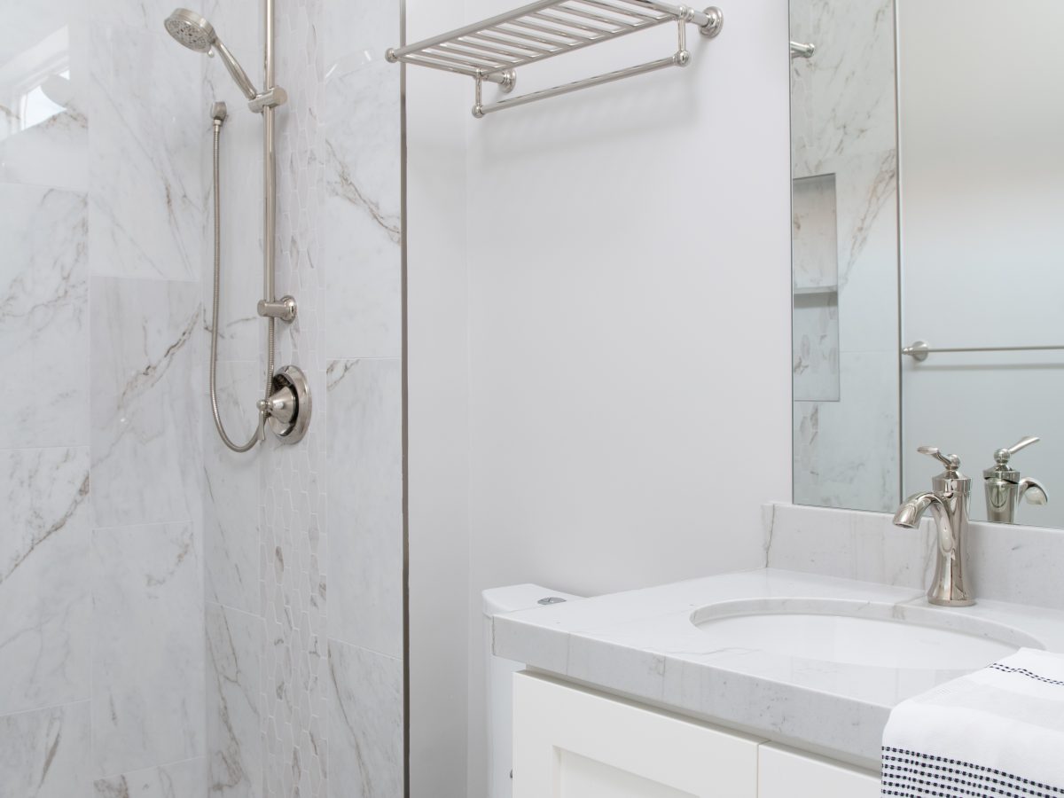 Transitional guest bathroom with stone-look porcelain tile and Taj Mahal quartzite vanity, Reveal Interior Design Las Vegas
