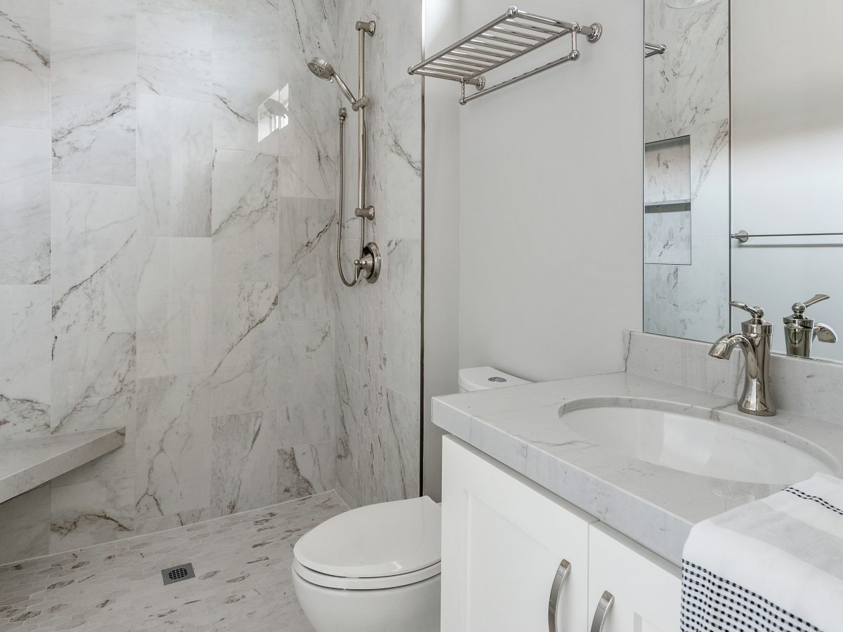 Transitional guest bathroom with stone-look porcelain tile and Taj Mahal quartzite vanity, Reveal Interior Design Las Vegas