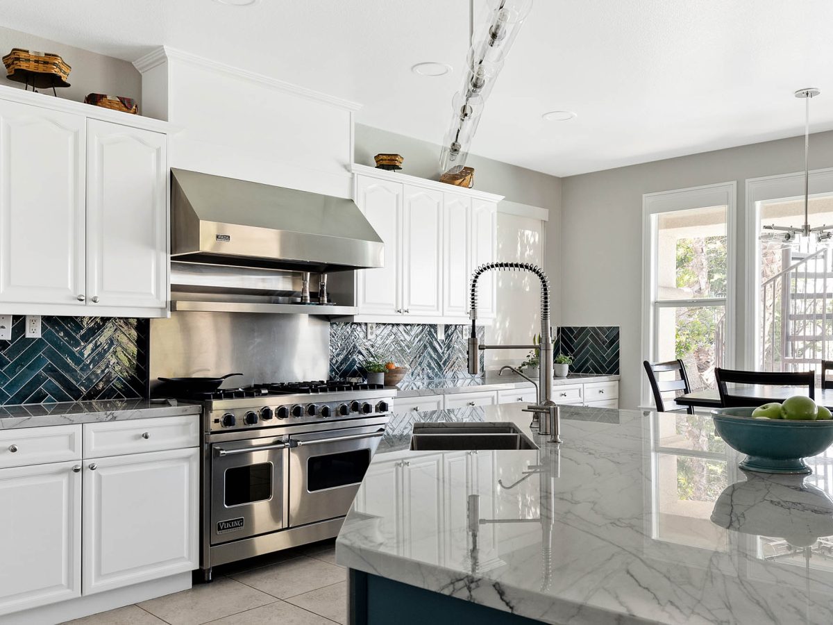 Transitional kitchen with blue-veined quartzite countertops and teal herringbone tile backsplash, Reveal Interior Design Las Vegas