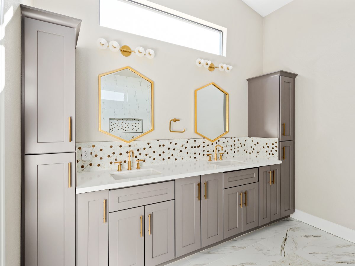 Primary bathroom with taupe shaker cabinetry, gold fixtures, and calacatta-look mosaic tile backsplash, Reveal Interior Design Las Vegas