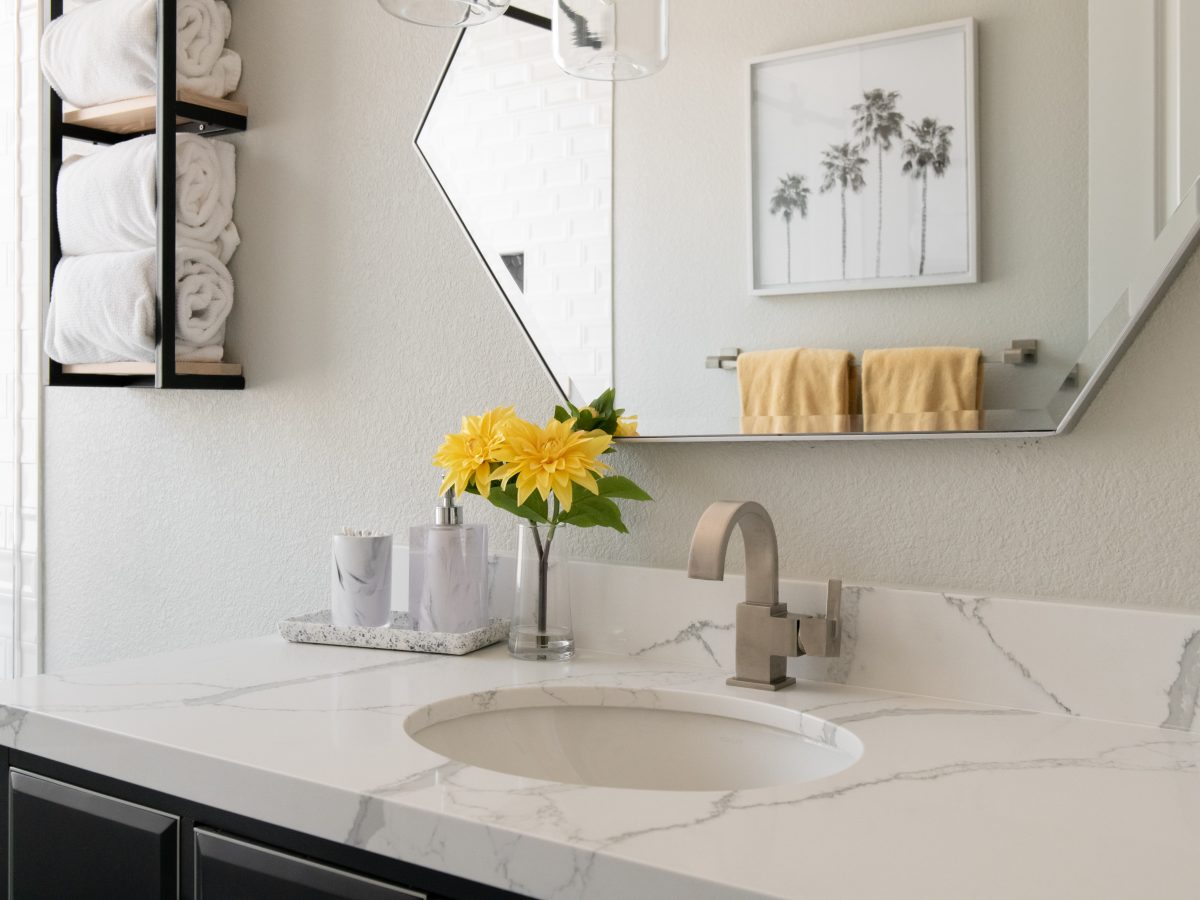 Hall bathroom with quartz countertop, hex mirror, and pendant lighting, Reveal Interior Design Las Vegas