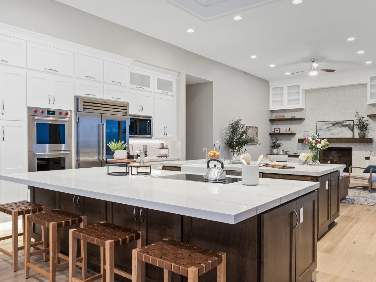 Transitional kitchen with Taj Mahal quartzite islands, dark stained maple and off-white shaker cabinetry, Reveal Interior Design Las Vegas