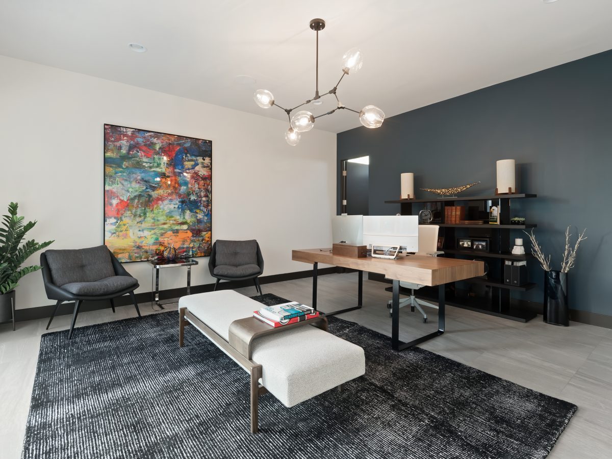 Modern home office with slate blue accent wall, wood desk, and sputnik chandelier, Reveal Interior Design Las Vegas