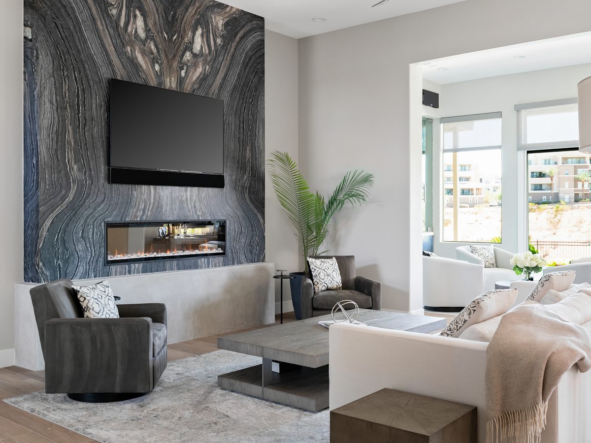Living room with bookmatched leathered quartzite slab fireplace wall and linear fireplace, Reveal Interior Design Las Vegas