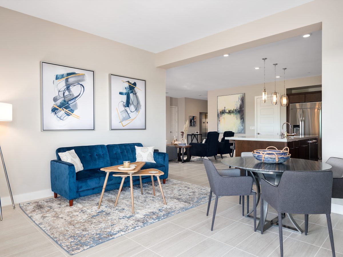 Contemporary multipurpose living and dining space with blue velvet sofa and concrete-top game table, Reveal Interior Design Las Vegas