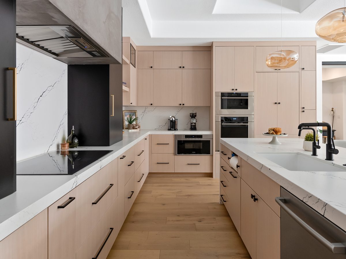 Modern kitchen with whitewashed oak cabinetry, black-veined white quartz countertops, and matte black accents, Reveal Interior Design Las Vegas