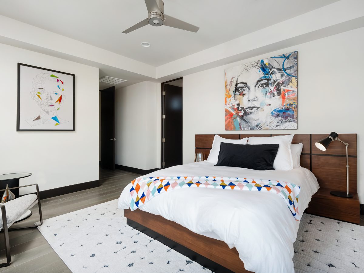 Contemporary secondary bedroom with bold figurative artwork and walnut platform bed, Reveal Interior Design Las Vegas