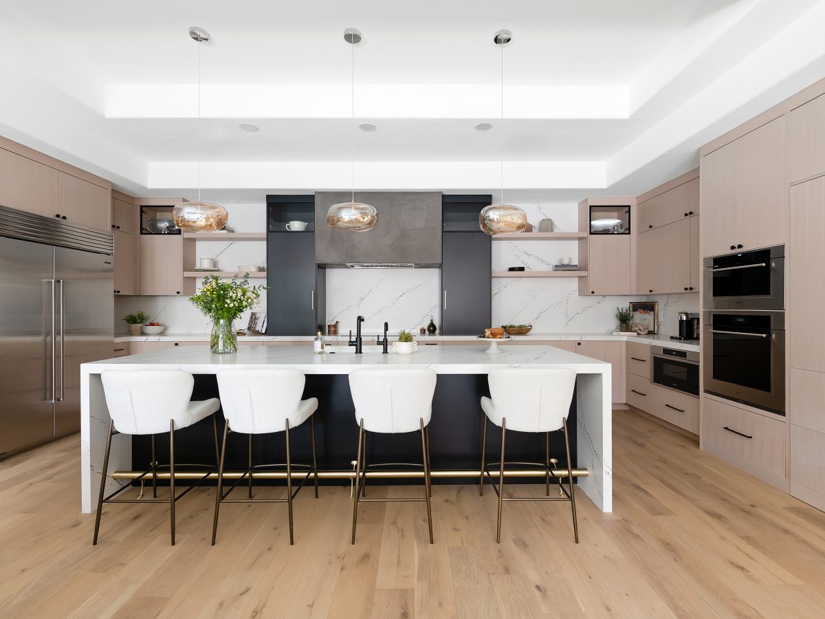 Modern kitchen with white-washed oak cabinetry, black quartz countertops, and warm engineered oak flooring, Reveal Interior Design Las Vegas