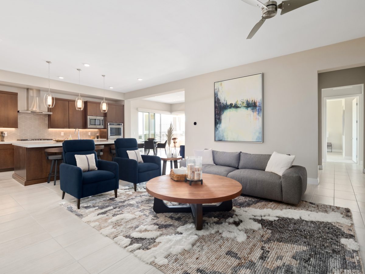 Open-concept living room with polished porcelain tile and gray sofa, Reveal Interior Design Las Vegas