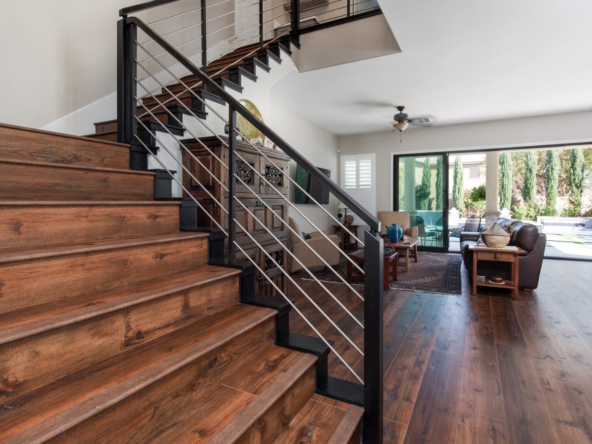 Living room with black metal cable stair railing and expansive black-trimmed sliding door, Reveal Interior Design Las Vegas