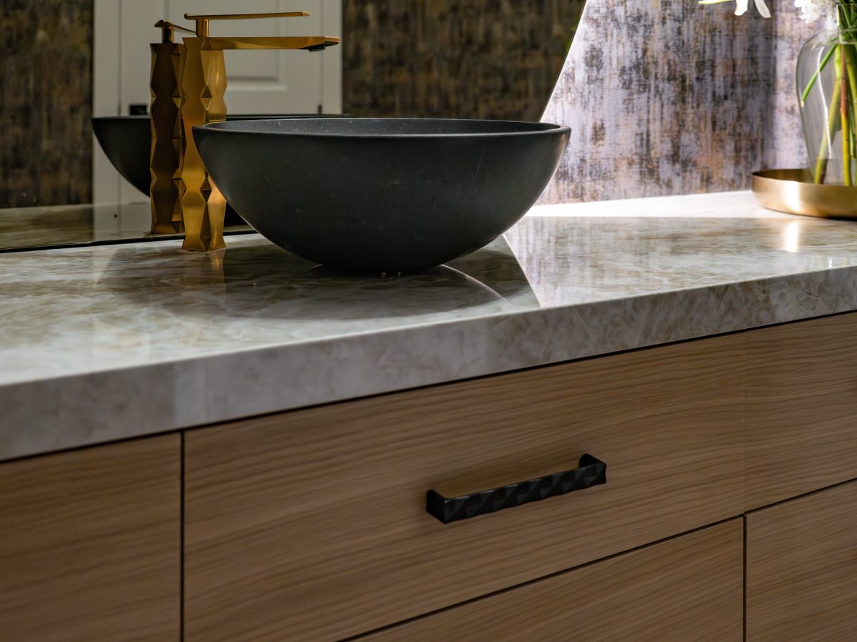Powder room floating white oak vanity with Taj Mahal Dekton countertop and stone vessel sink, Reveal Interior Design Las Vegas