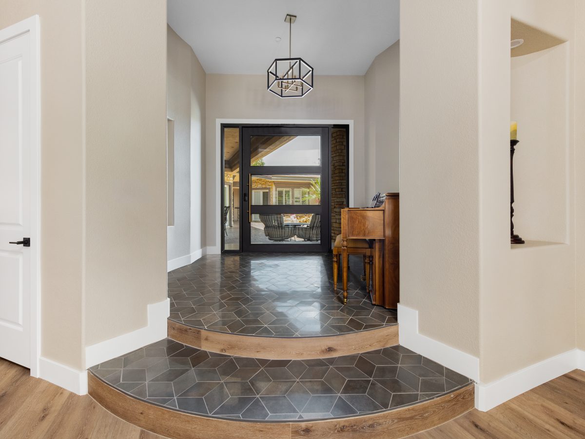 Transitional luxury foyer with geometric tile steps and geometric pendant light, Reveal Interior Design Las Vegas