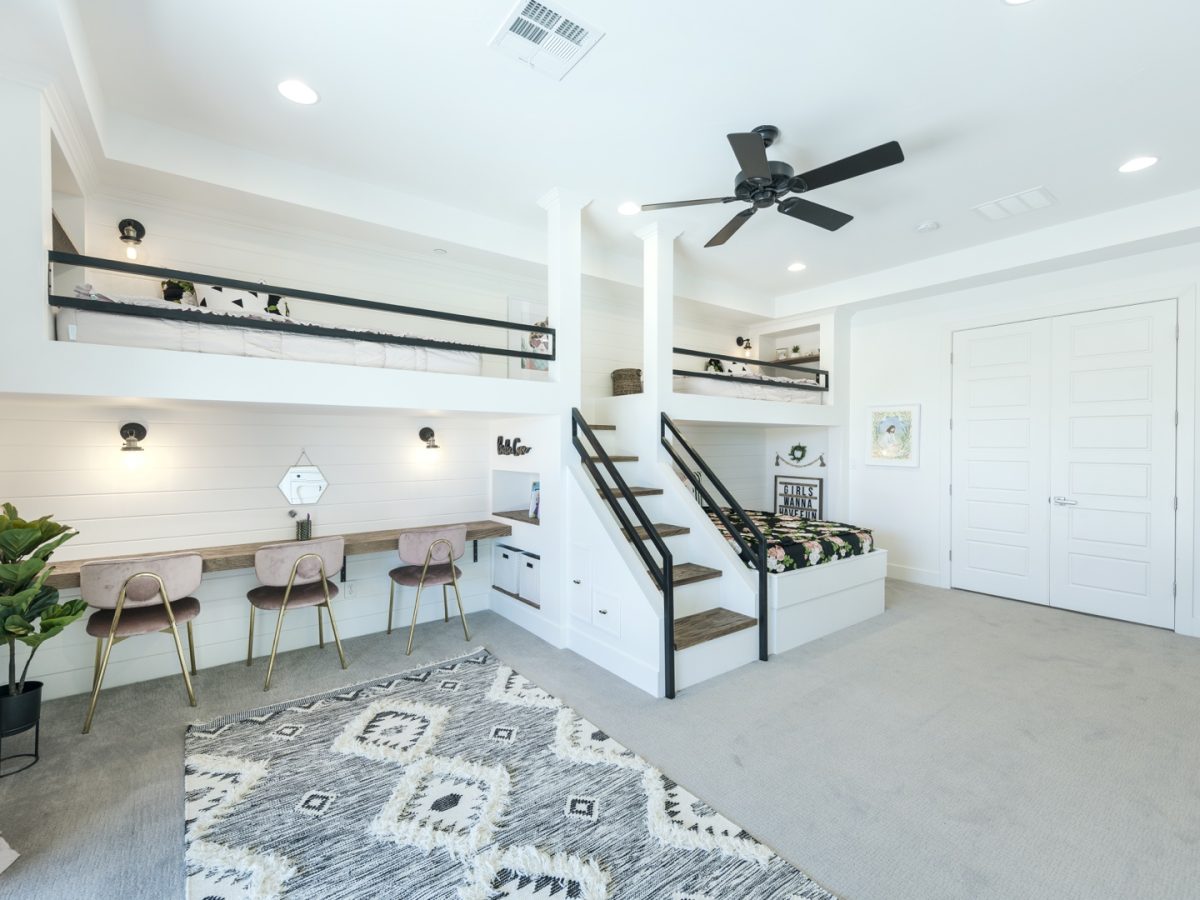Custom three-bed bunk room with built-in desk and black metal railings, Reveal Interior Design Las Vegas