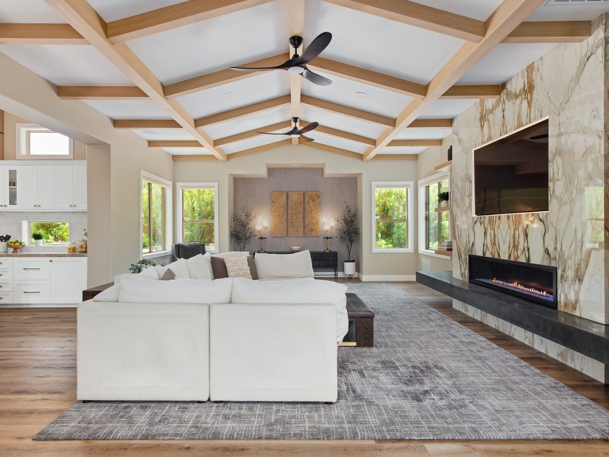 Living room with bookmatched porcelain fireplace surround, oak beam ceiling, and linear fireplace, Reveal Interior Design Las Vegas