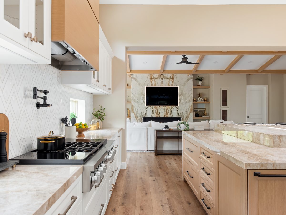 Luxury kitchen with Dekton Taj Mahal countertops, geometric stone backsplash, and custom wood hood, Reveal Interior Design Las Vegas