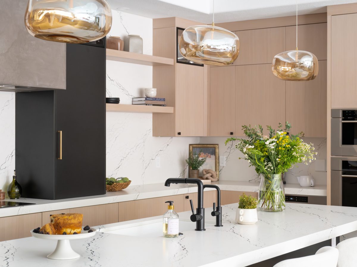 Contemporary kitchen with white-washed oak cabinetry, black quartz countertops, and amber glass pendants, Reveal Interior Design Las Vegas