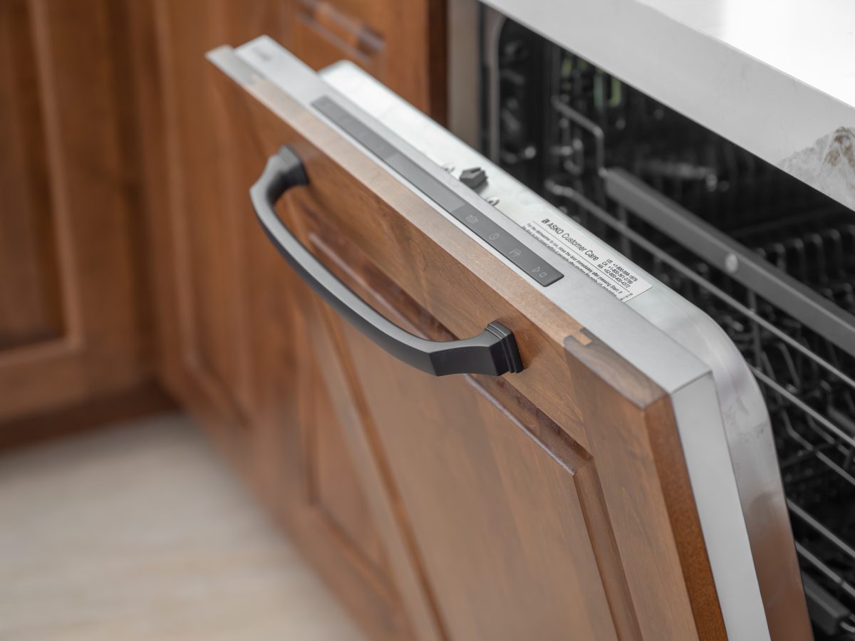 Kitchen dishwasher with custom walnut panel and dark bronze hardware, Reveal Interior Design Las Vegas
