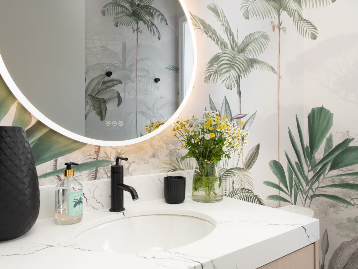 Tropical mural powder bath with stone vanity countertop and round LED mirror, Reveal Interior Design Las Vegas