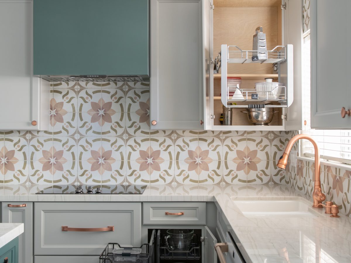 Kitchen with encaustic ceramic tile backsplash, emerald and beige cabinetry, copper hardware, Reveal Interior Design Las Vegas