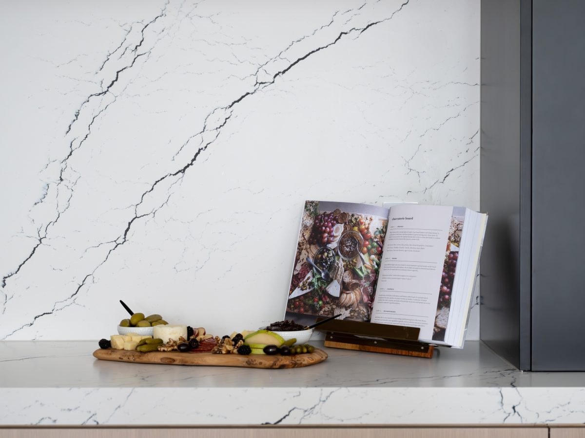 Kitchen with black-veined white quartz countertops and backsplash, white-washed oak cabinetry, Reveal Interior Design Las Vegas