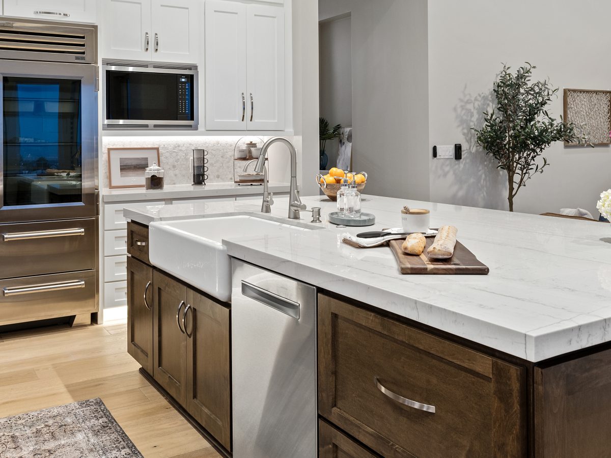 Transitional kitchen with Taj Mahal quartzite island, dark stained maple and off-white cabinetry, Reveal Interior Design Las Vegas