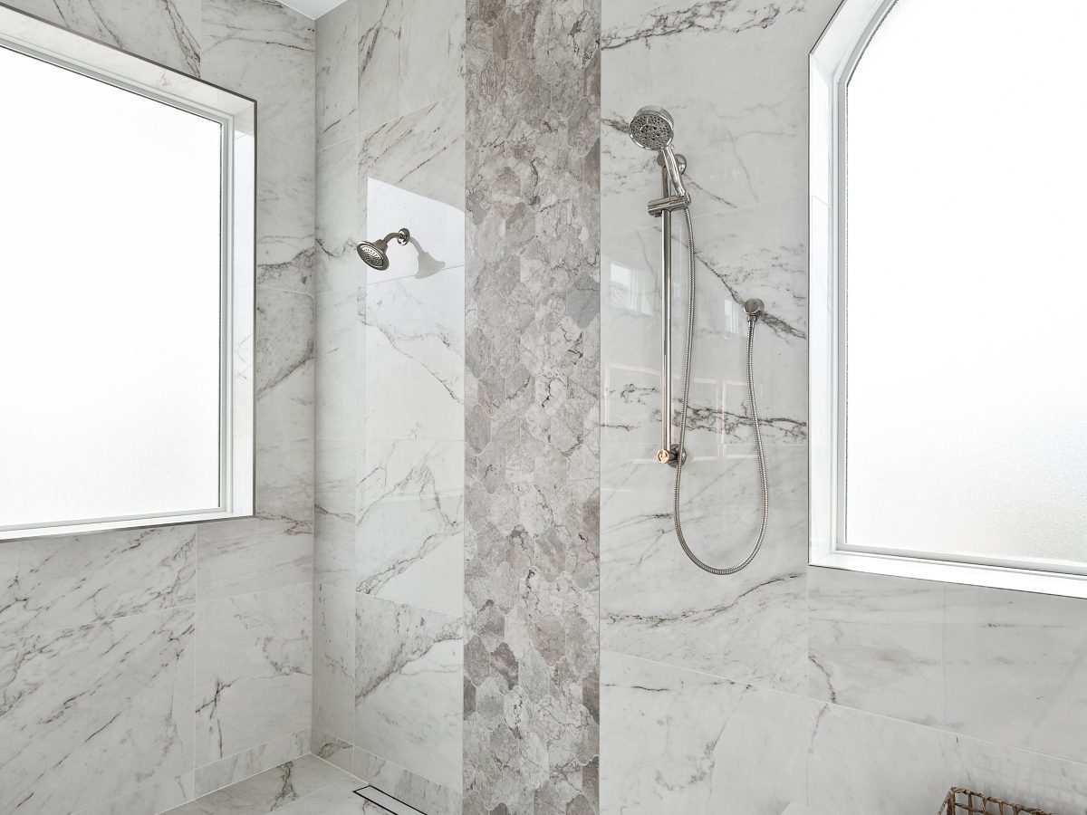 Transitional wet room with marble-look porcelain tile, polished nickel fixtures, and floating bench, Reveal Interior Design Las Vegas