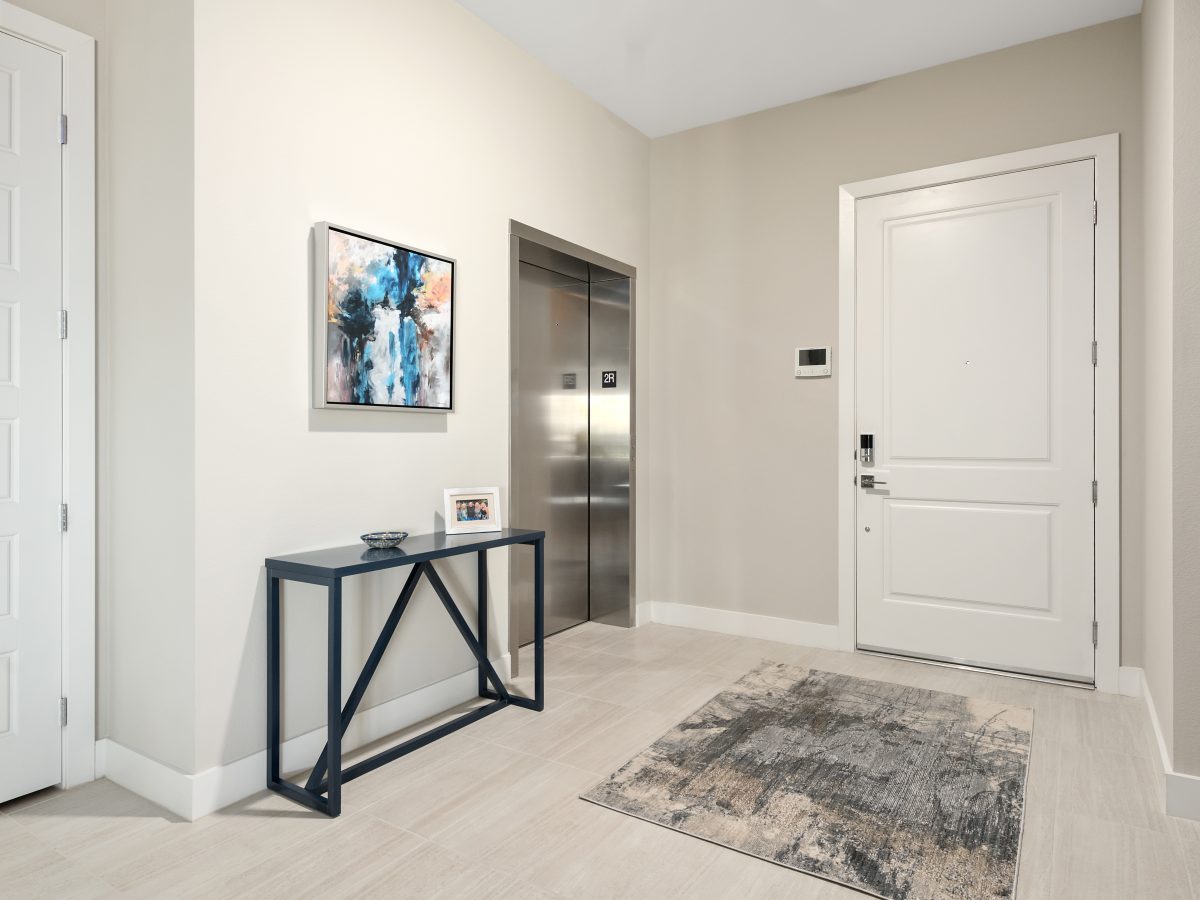 Contemporary multipurpose lounge with concrete-top game table, blue sofa, and gallery wall art, Reveal Interior Design Las Vegas