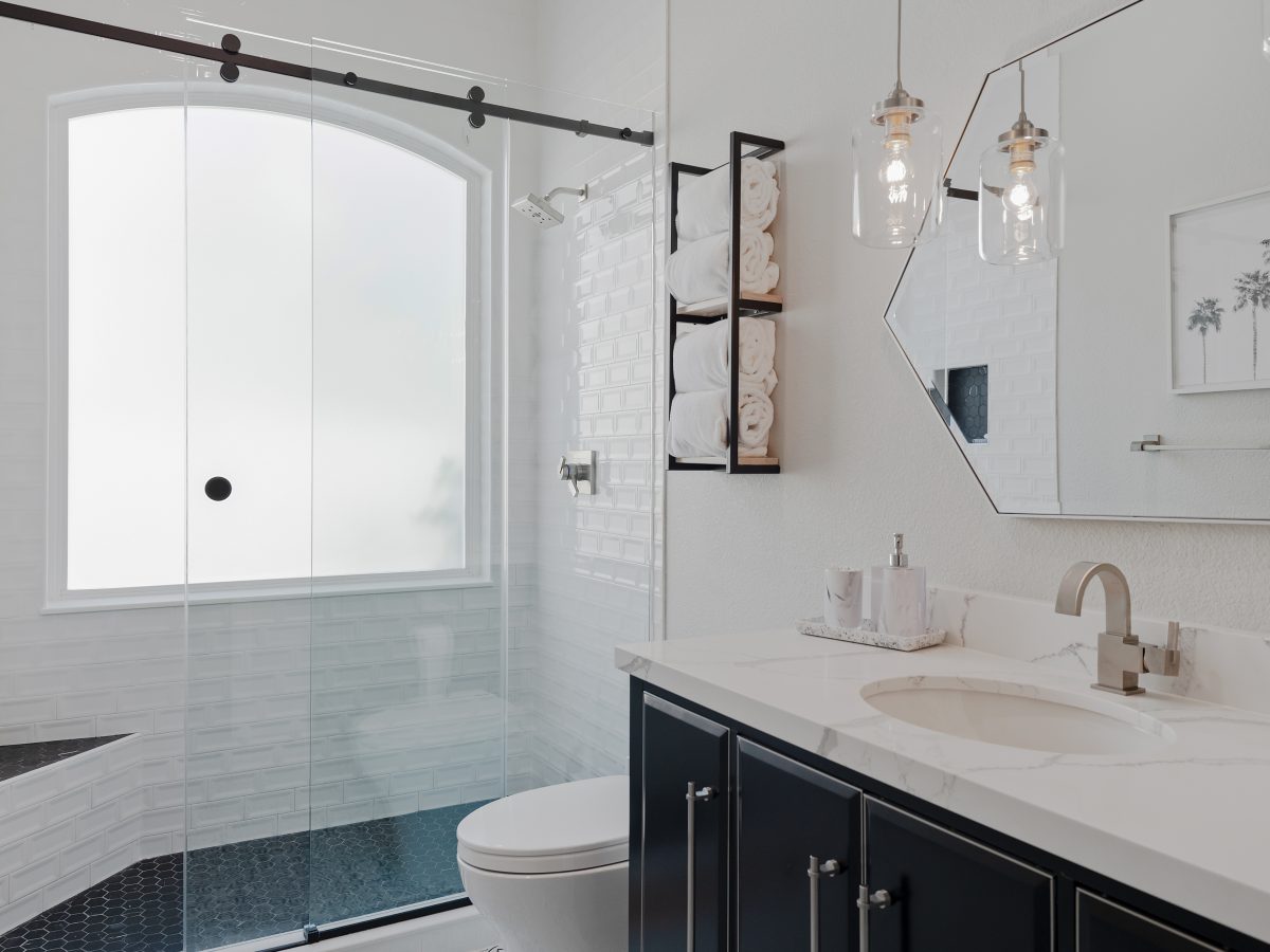 Hall bathroom with furniture-style vanity, quartz countertop, and glass-enclosed subway tile shower, Reveal Interior Design Las Vegas